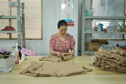 A los trabajadores les pagan por pieza y el horario laboral estándar es de 8 a 22 (Xiqing Wang/BBC)