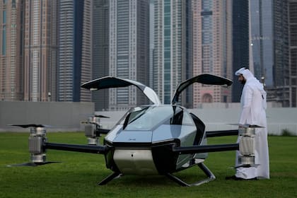 A man looks at the XPeng X2, an electric flying taxi developed by the Guangzhou-based XPeng, Inc's aviation affiliate, being tested in front of the Marina District in Dubai, United Arab Emirates, Monday, Oct. 10, 2022. Monday’s demonstration was held with an empty cockpit, but the company says it carried out a manned flight test last year of the two-passenger vehicle. (AP Photo/Kamran Jebreili)