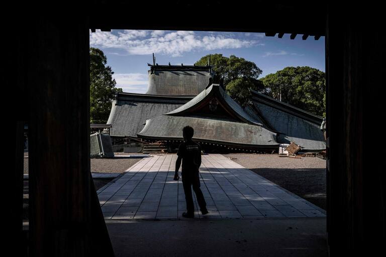 A man visits the collapsed Yatsushiro Shrine in Yatsushiro, Kumamoto prefecture on July 29, 2026, after an earthquake struck southwestern Japan the previous day. (Photo by Yuichi YAMAZAKI / AFP)