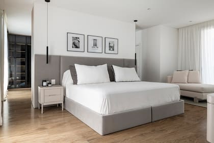 A partir del sommier comprado por los clientes, el Estudio diseñó a medida la caja entelada en gris, mismo género de Tienda Mayor elegido para el respaldo. Vestidor con puertas traslúcidas con vidrios fumé negros.