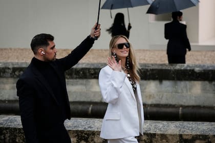 A pesar de la lluvia, Charlize Theron dijo presente en el desfile de Givenchy. La actriz sudafricana eligió un traje off white que combinó con gafas negras