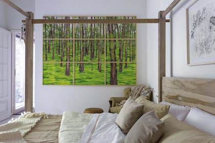 Cama (Paul French Gallery) vestida en blanco y tonos tierra. En la cabecera, obra de Camila Vilar. Políptico de Sofía Wiñazki (Galería Mar Dulce).