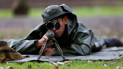 A unos 100 metros de distancia, un tirador con un fusil de precisión hiere levemente a un delincuente que cubría una puerta de acceso a la finca, donde hay un inocente cautivo.