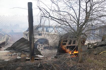 Escombros de una casa y un automóvil quemado después del bombardeo ruso, en las afueras de Kiev (Foto AP/Efrem Lukatsky)