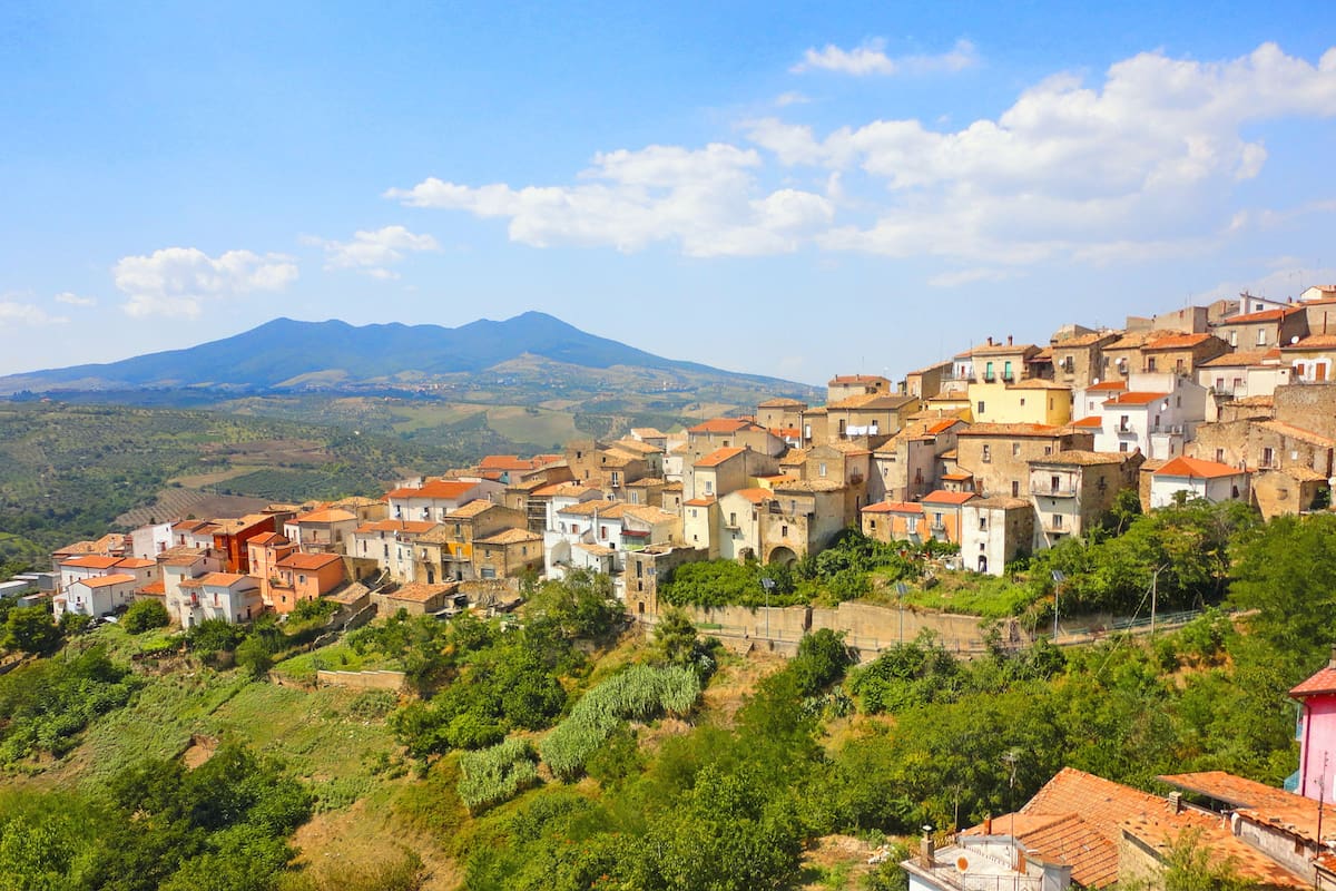 A view on the roofs of old village Ripacandida with old houses on green hill and big mountain Vulture in background. Basilicata South Italy