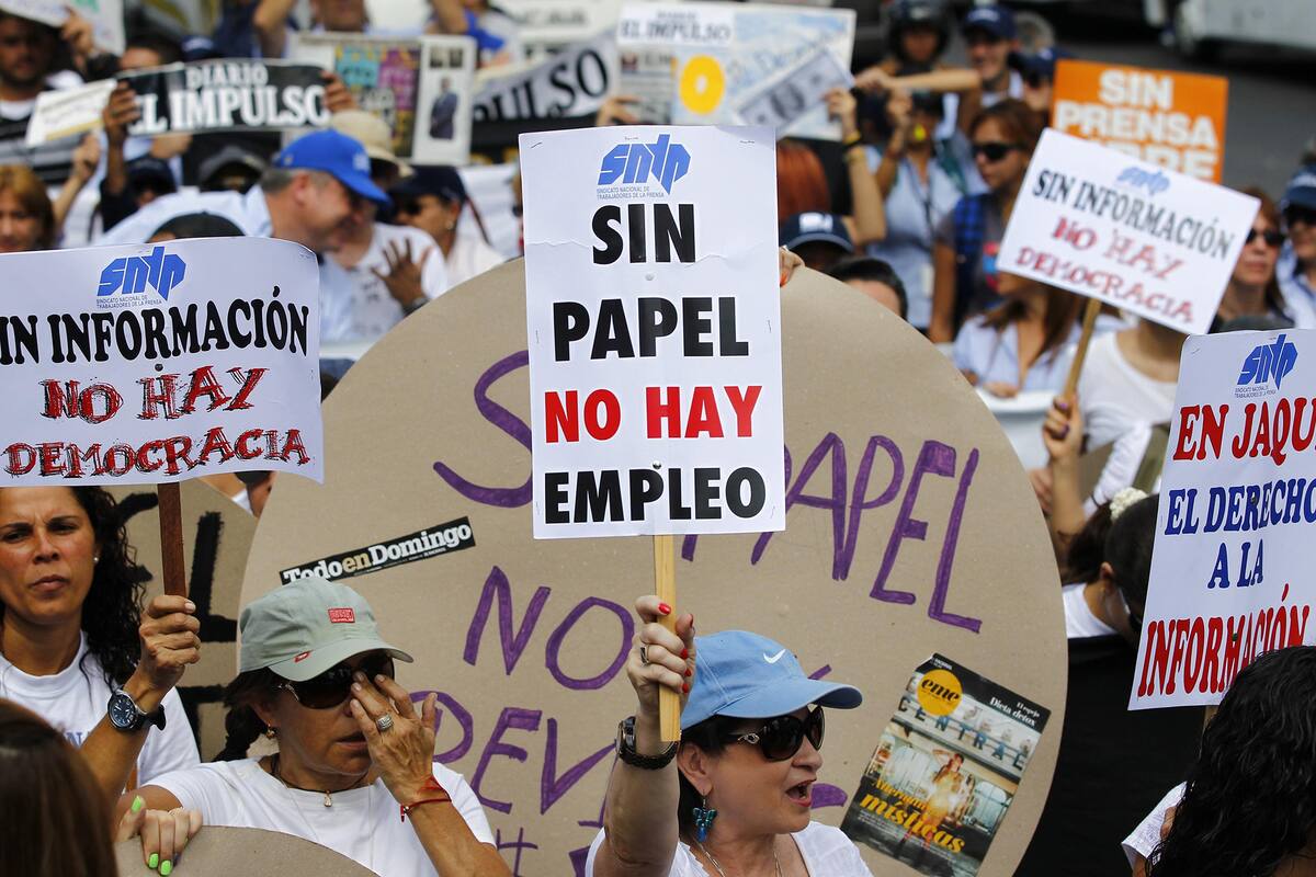 A woman holds up a sign reading "No paper, no jobs", during a protest by newspaper workers and opposition parties to demand from the government U.S. dollars at a prime rate to buy paper for their publications, in Caracas February 11, 2014. Newspaper owners claim they are close to running out of their stock of paper due to the lack of dollars to import it, local media said. REUTERS/Carlos Garcia Rawlins (VENEZUELA - Tags: POLITICS CIVIL UNREST MEDIA BUSINESS EMPLOYMENT)