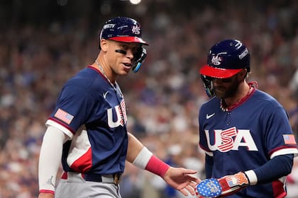 Aaron Judge, izquierda, y Bryce Harper, derecha, de Estados Unidos, celebran luego de anotar durante la tercera entrada del juego de béisbol del Clásico Mundial ante Canadá, el viernes 13 de marzo de 2026, en Houston. (AP Foto/David J. Phillip)