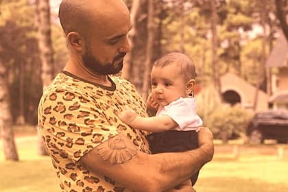 Abel Pintos sosteniendo en brazos a su hijo Agustín