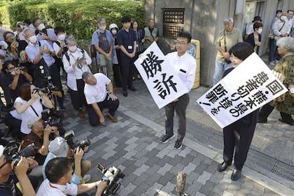 Abogados sostienen letreros con la palabra "Victoria" en japonés luego del veredicto en el tribunal de distrito de Osaka, en el oeste de Japón, el miércoles 27 de septiembre de 2023. (Kyodo News vía AP)