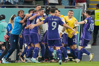 Abrazados, los jugadores y el cuerpo técnico argentino celebran el primer gol contra Polonia