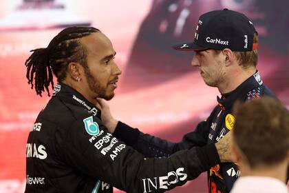 ABU DHABI, UNITED ARAB EMIRATES - DECEMBER 12: Race winner and 2021 F1 World Drivers Champion Max Verstappen of Netherlands and Red Bull Racing is congratulated by runner up in the race and championship Lewis Hamilton of Great Britain and Mercedes GP during the F1 Grand Prix of Abu Dhabi at Yas Marina Circuit on December 12, 2021 in Abu Dhabi, United Arab Emirates. (Photo by Lars Baron/Getty Images)