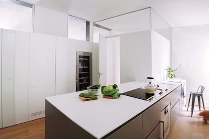 Acá el estudio Ábaton puso vidrio en la parte superior de la pared para compartir la luz que llega desde el comedor sin exponer la cocina a la zona social.