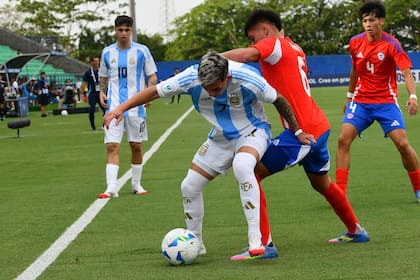 Acevedo protege la pelota en Montería, observado por su compañero Francisco Baridó, futbolista de Juventus formado en Boca.