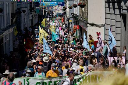 Activistas marchan por las calles de Falmouth, Inglaterra, el sábado 12 de junio de 2021 durante una manifestación en el marco de la reunión del G7. (AP Foto/Alberto Pezzali)