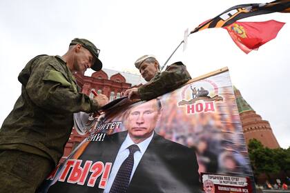 Activistas sostienen un retrato del presidente ruso Vladimir Putin cerca de la Plaza Roja en Moscú, el 24 de junio de 2023.