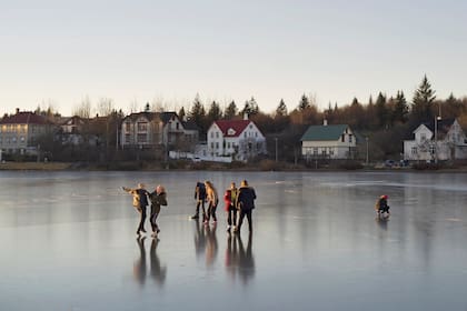 Adolescentes disfrutan del lago congelado en la capital, cuando los días empiezan a extenderse. En verano hay luz natural 24 horas