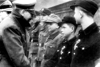 Adolf Hitler, a la izquierda, le da la mano a Alfred Czech, un soldado de la Juventud Hitleriana de 12 años en una de sus últimas apariciones. Alemania el 19 de marzo de 1945.