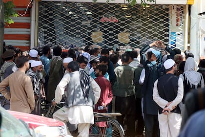 Afganos esperan durante horas para retirar dinero ante el Banco de Kabul, en Kabul, Afganistán, el 28 de agosto de 2021. (AP Foto/Khwaja Tawfiq Sediqi)