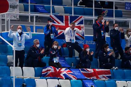 Aficionados británicos celebran una jugada de su equipo en la semifinal femenina de curling que enfrentó a Gran Bretaña y Suecia en los Juegos Olímpicos de Invierno, el 18 de febrero de 2022, en Beijing. (AP Foto/Brynn Anderson)