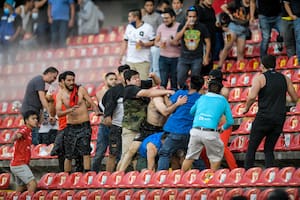 Aficionados chocan durante un partido de la liga mexicana de fútbol entre el anfitrión Querétaro y Atlas de Guadalajara, en el estadio Corregidora, en Querétaro, México, el sábado 5 de marzo de 2022.