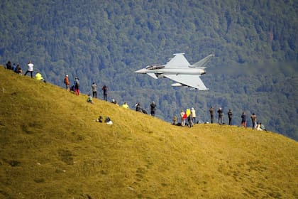 Aficionados de la aviación observan el sobrevuelo de un avión Eurofighter Typhoon de la Fuerza Aérea Alemana durante una exhibición de aviación militar y acrobática cerca de la Cruz de los Héroes en el pico Caraiman, en la cima de las montañas Bucegi, en Busteni, Rumania
