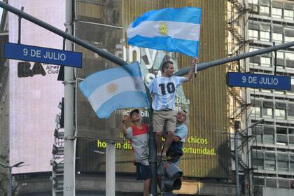 Aficionados de la selección de Argentina celebran el triunfo ante Polonia que le dio el pase a los octavos de final al equipo, cerca del Obelisco en Buenos Aires el miércoles 30 de noviembre del 2022. (AP Foto/Gustavo Garello)