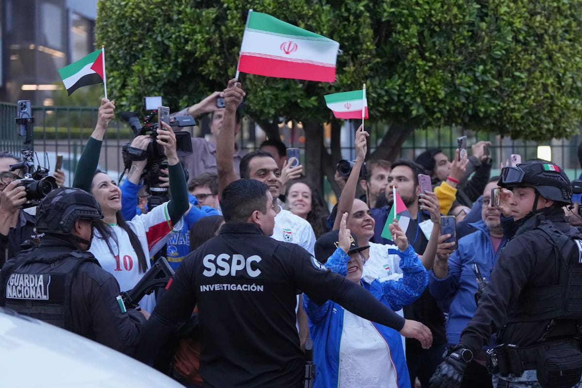 Aficionados de la selección iraní de fútbol saludan a la llegada de los jugadores que disputarán el Mundial a Tijuana, México, el 7 de junio de 2026. (AP Foto/Gregory Bull)