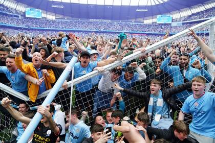 Aficionados del Manchester City invaden la cancha después de que su equipo ganara la Premier League inglesa tras vencer 3-2 al Aston Villa en el Etihad Stadium, Manchester
