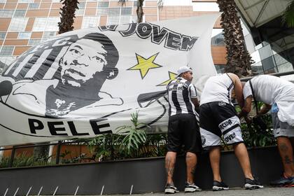 Aficionados del Santos de Brasil colocan una manta con la imagen del astro Pelé frente al hospital Albert Einstein en Sao Paulo en donde se encuentra hospitalizado el domingo 4 de diciembre del 2022. (AP Foto/Marcelo Chello)