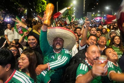 Aficionados mexicanos celebran la victoria de la selección de su país ante Corea del Sur en el Ángel de la Independencia de Ciudad de México, el jueves 18 de junio de 2026 (AP Foto/Marco Ugarte)