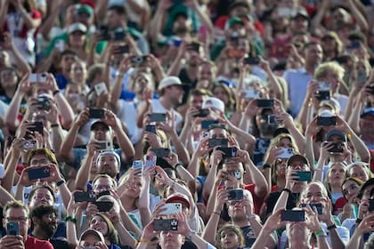 Aficionados toman fotos y videos con sus teléfonos durante el partido por el Grupo J del Mundial entre Argelia y Austria, el sábado 27 de junio de 2026, en Kansas City. (AP Foto/Charlie Riedel)