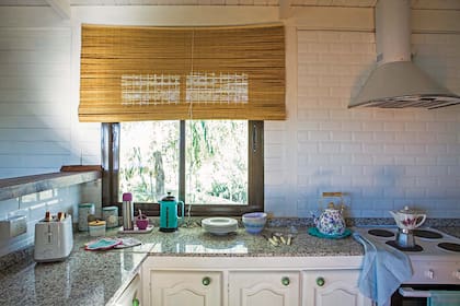 En la cocina, agarraderas tejidas a crochet, repasadores, pava enlozada y cafetera Volturno vintage de porcelana (todo de Don Terrenal).