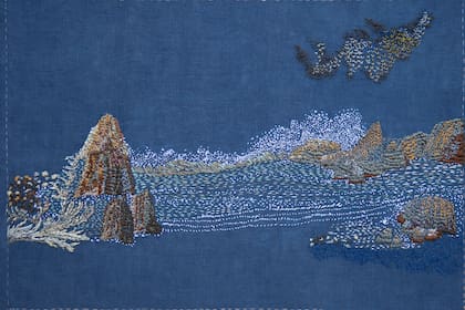El mar, las rocas y las aves crean un paisaje minimalista y sereno en Sueño despierta, la obra realizada sobre lino, bordada con hilos de rayón y algodón.