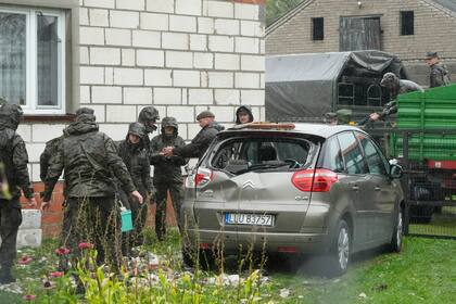 Agentes de defensa territorial retiran los restos del techo destruido de una vivienda, después de que drones rusos violara el espacio aéreo de Polonia en un ataque contra Ucrania, en Wyryki, cerca de Lublin, Polonia, el jueves 11 de septiembre de 2025. (AP Foto/Czarek Sokolowski)