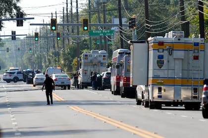 Agentes de distintas corporaciones van al lugar donde se reportó un tiroteo, en una sucursal de la cadena Dollar General (AP Foto/John Raoux)