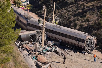 Agentes de la Guardia Civil recogen pruebas junto a los restos de vagones de tren implicados en una colisión en Adamuz, sur de España, martes 20 de enero de 2026