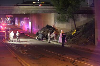 Agentes de la patrulla de caminos de California trabajan en la escena de un accidente de auto en que dos adolescentes murieron en el lugar y un tercero en el hospital. (AP Foto/James Carbone)