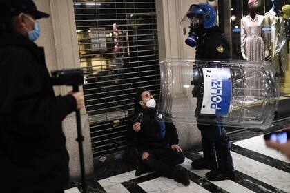 Agentes de la policía italiana detienen a un activista de extrema derecha durante una protesta contra las medidas de restricción del gobierno para frenar la propagación del coronavirus, en el centro de Turín, el 26 de octubre de 2020