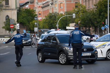 Agentes de la policía local controlan el movimiento de personas en un puesto de control de tráfico en Madrid