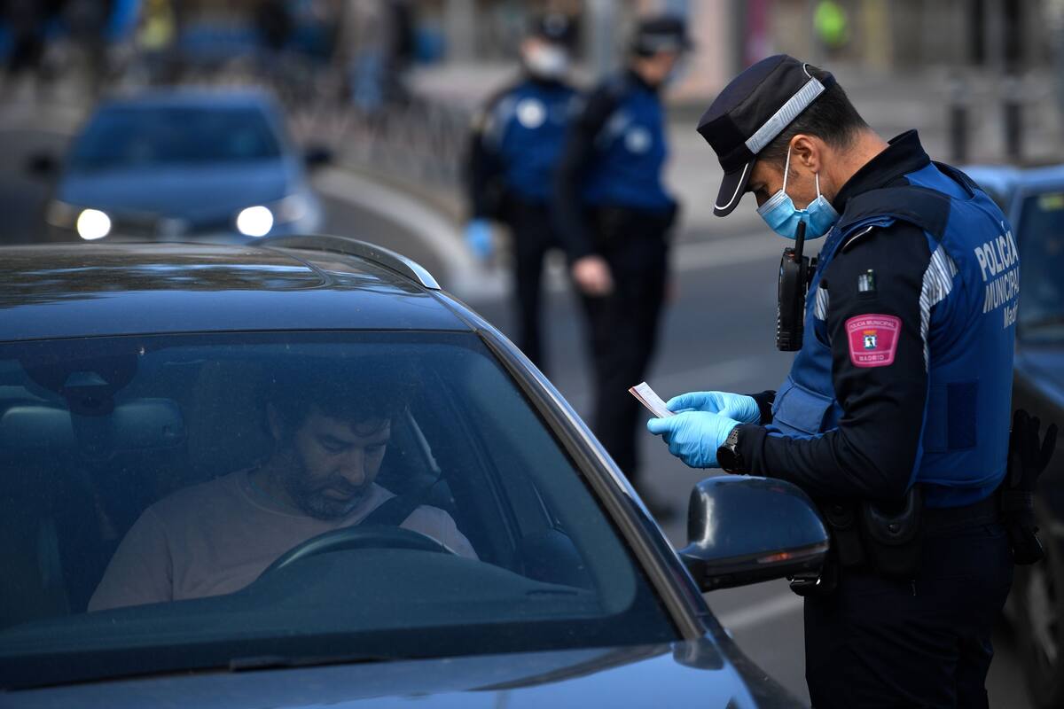 Agentes de la policía local controlan el movimiento de personas en un puesto de control de tráfico en Madrid