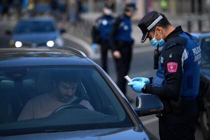 Agentes de la policía local controlan el movimiento de personas en un puesto de control de tráfico en Madrid