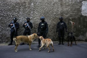 Agentes de la Policía Nacional hacen guardia previo a una conferencia de prensa sobre la extradición desde Estados Unidos de miembros de la pandilla Tren de Aragua y su llegada a una penitenciaría de máxima seguridad en Santiago, Chile, el miércoles 1 de octubre de 2025. (AP Foto/Esteban Félix)