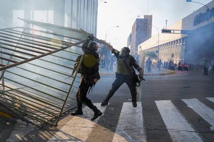 Agentes de la policía retiran barricadas colocadas por manifestantes contra el gobierno en Lima, Perú, el martes 24 de enero de 2023. (AP Foto/Martin Mejia)