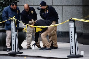 Agentes de la unidad de asesinatos de la policía de Nueva York colocan vasos para marcar los lugares donde cayeron las balas mientras investigan en las inmediaciones del hotel Hilton de Manhattan, donde Brian Thompson, CEO of UnitedHealthcare, fue asesinato a tiros, el 4 de diciembre de 2024, en Nueva York. (AP Foto/Stefan Jeremiah)