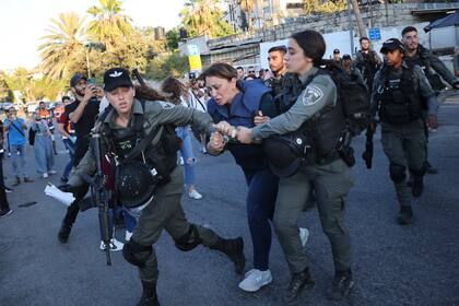 Agentes de las fuerzas de seguridad israelíes detienen a la periodista de Al Jazeera Givara Budeiri, durante una protesta en el barrio de Sheikh Jarrah, Jerusalén Oriental, el sábado 5 de junio de 2021. (AP Foto/Oren Ziv)