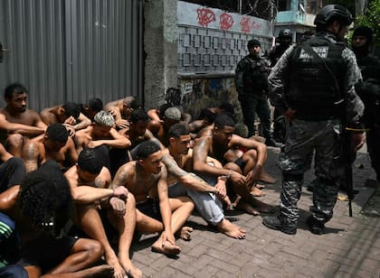 Agentes de policía custodian a presuntos delincuentes arrestados durante la Operación Contención en la favela Vila Cruzeiro, en el complejo Penha, Río de Janeiro