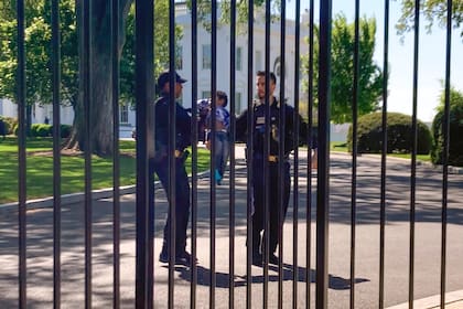 Agentes de policía de la división uniformada del Servicio Secreto de EE.UU. llevan a un niño pequeño que gateó a través de la valla de la Casa Blanca en la Avenida Pennsylvania, en Washington