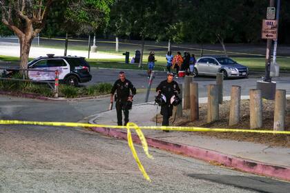 Agentes de policía dejan el lugar de un tiroteo en el parque Peck, el domingo 24 de julio de 2022, en San Pedro, California.