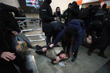 Agentes de policía detienen a manifestantes en una estación de metro durante una marcha contra la decisión del gobierno de suspender las negociaciones de ingreso a la Unión Europea durante cuatro años, en Tiflis, Georgia, el lunes 2 de diciembre de 2024. (AP Foto/Zurab Tsertsvadze)