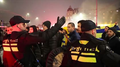 Agentes de policía escoltan a aficionados del Maccabi de Tel Aviv a una estación de metro próxima al estadio del Ajax